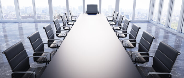 large boardroom with long table and empty chairs