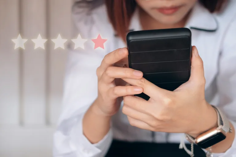businesswoman holding phone with one star review to the left