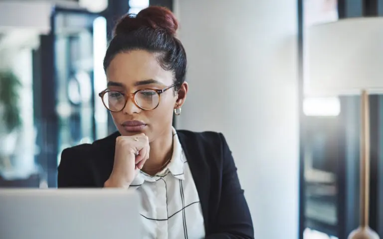 female attorney looking at laptop screen assessing website providers for her law firm