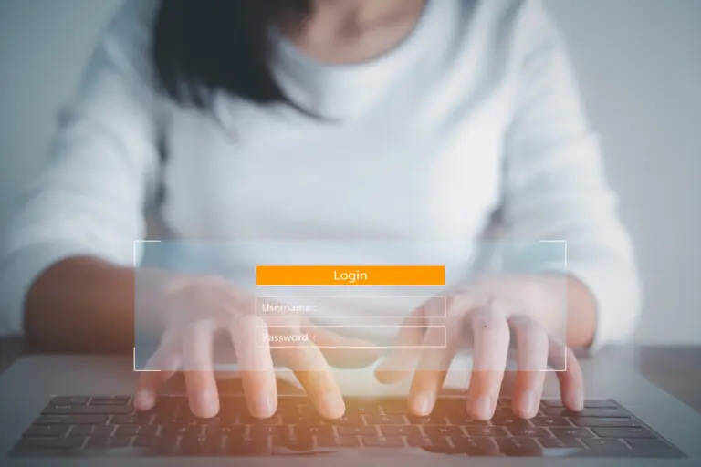 women's hands typing username and password on secured website