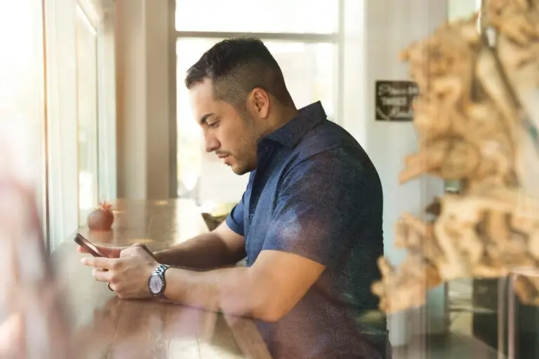 man looks at phone in hands