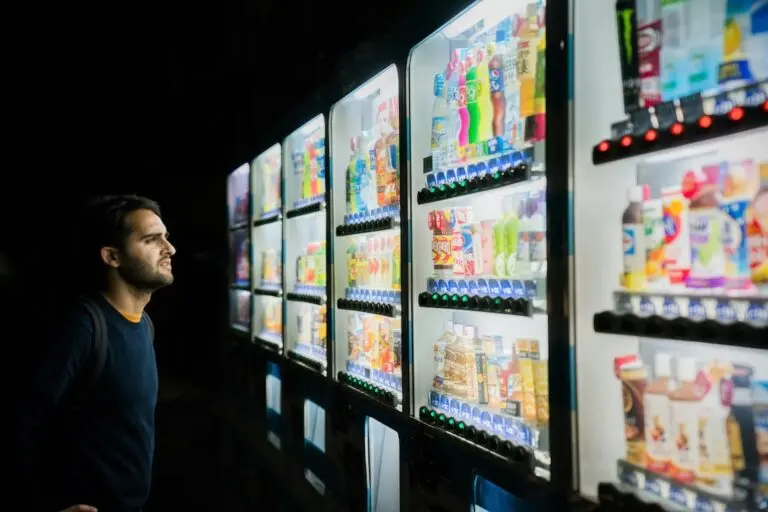 man staring at wall with dozens of beverage options